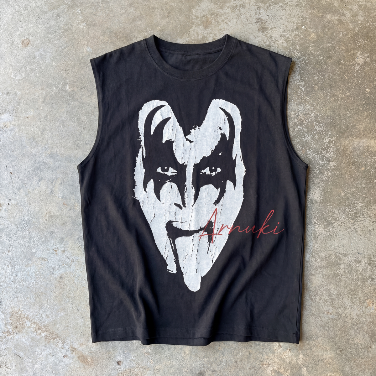 Black sleeveless shirt with white graphic design on a concrete surface