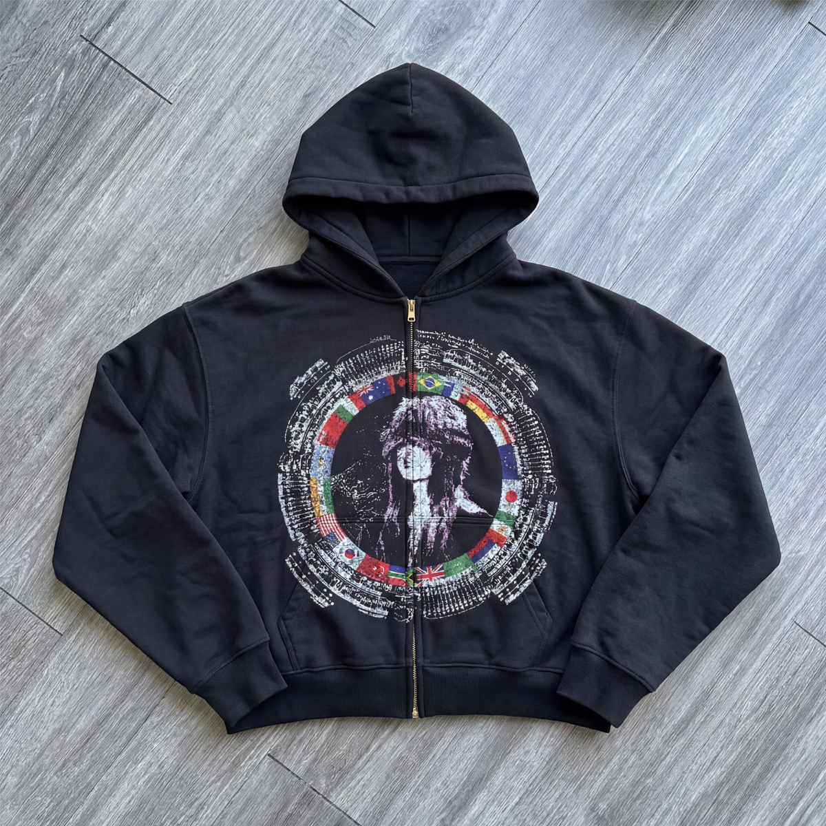 Black hoodie with a colorful graphic design on a wooden floor